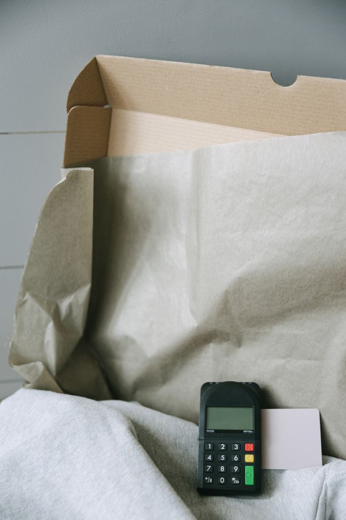gallery-6 Image of a payment terminal with a cardboard box and paper, representing online shopping and contactless payment.